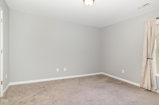 carpeted spare room featuring visible vents and baseboards