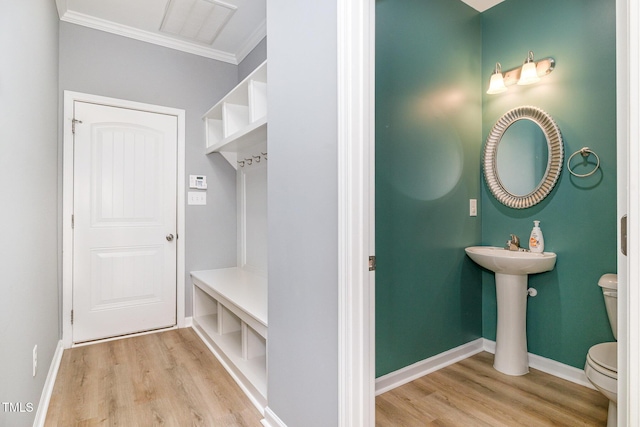 mudroom featuring light wood-type flooring, visible vents, crown molding, and baseboards