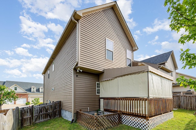 rear view of house featuring a fenced backyard, a yard, and a deck