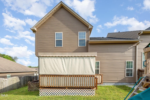back of house with fence and a lawn