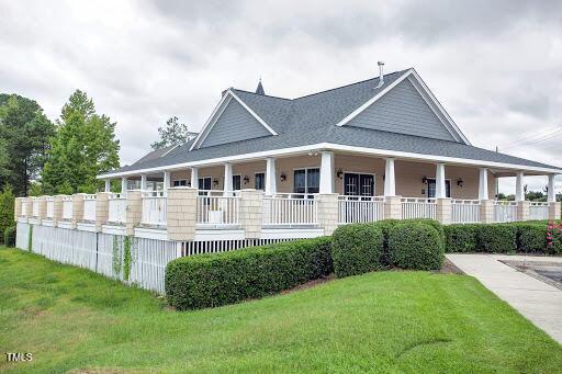 farmhouse-style home featuring a porch and a front yard