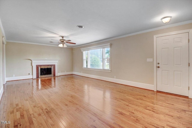 unfurnished living room featuring crown molding, ceiling fan, light hardwood / wood-style floors, and a brick fireplace