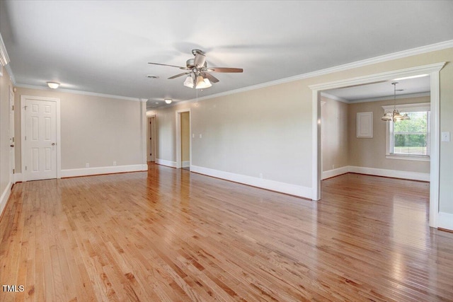 empty room featuring ceiling fan with notable chandelier, crown molding, and light hardwood / wood-style flooring