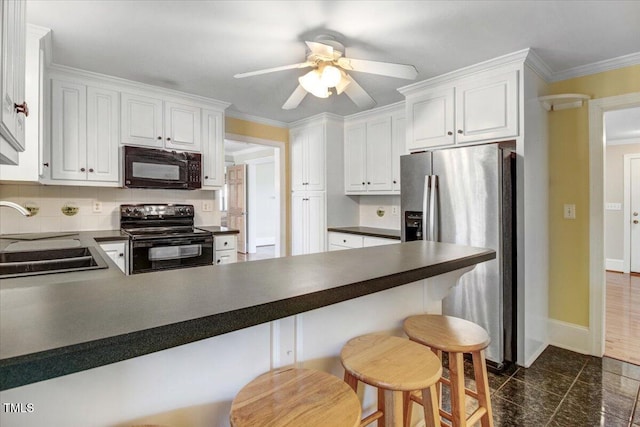 kitchen with ornamental molding, a breakfast bar, sink, black appliances, and white cabinetry