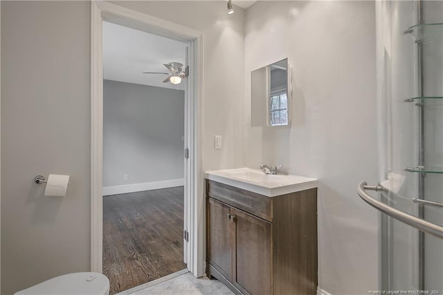 bathroom featuring wood-type flooring, vanity, toilet, and ceiling fan