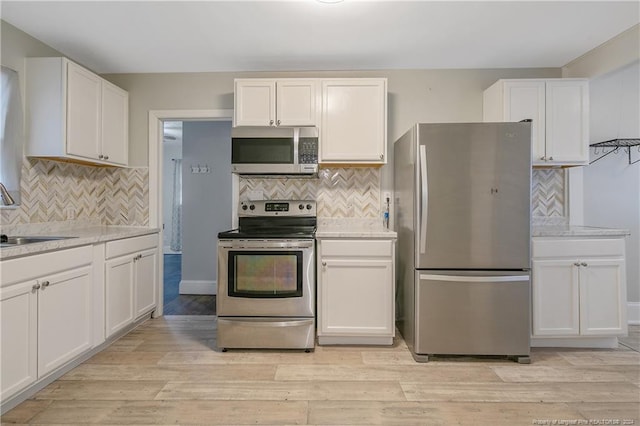 kitchen featuring light hardwood / wood-style floors, sink, white cabinetry, and stainless steel appliances