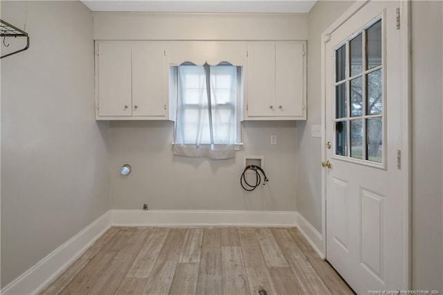 clothes washing area featuring gas dryer hookup, light hardwood / wood-style flooring, cabinets, and washer hookup