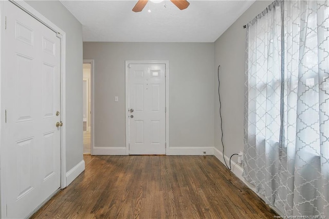 interior space with ceiling fan and dark wood-type flooring