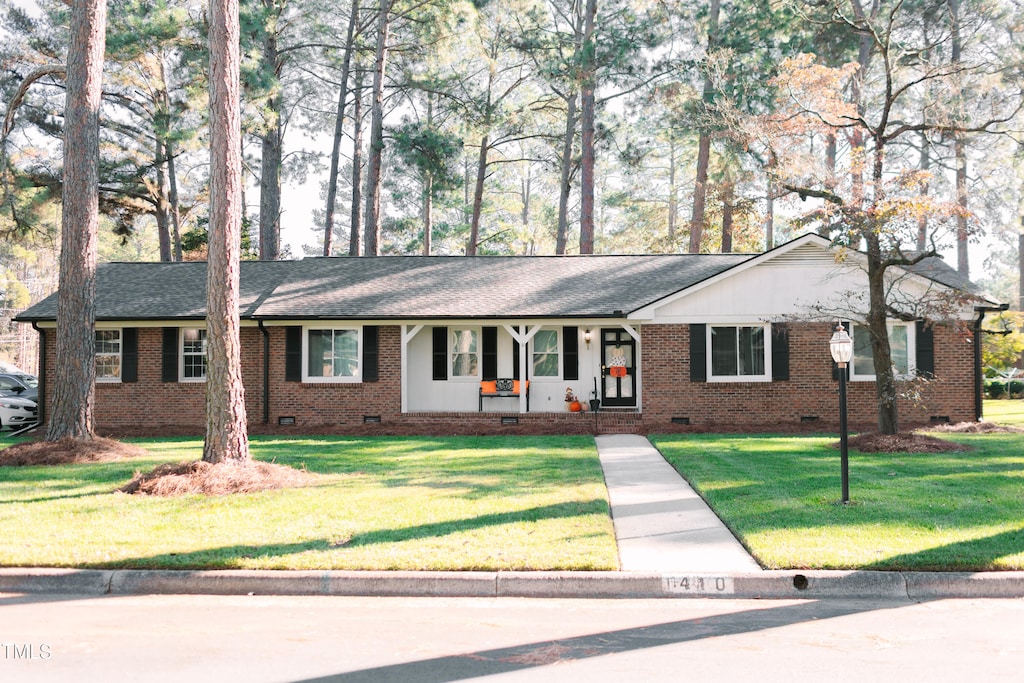 ranch-style house with a front yard and a porch