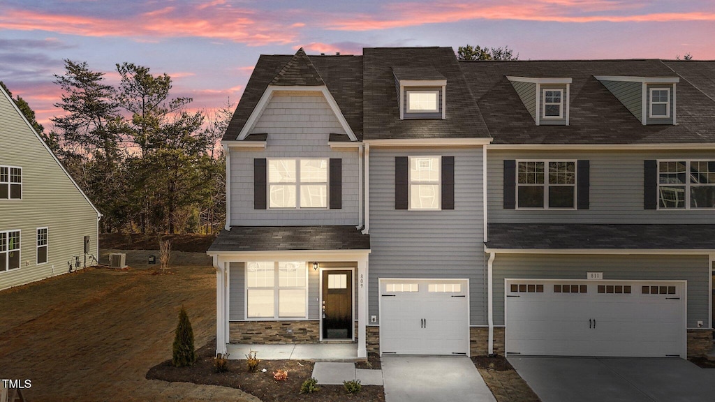 view of front facade featuring a garage and central AC