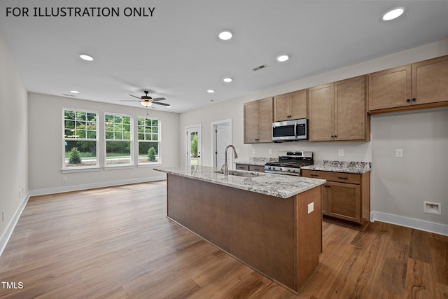 kitchen featuring sink, light hardwood / wood-style flooring, a center island with sink, and appliances with stainless steel finishes