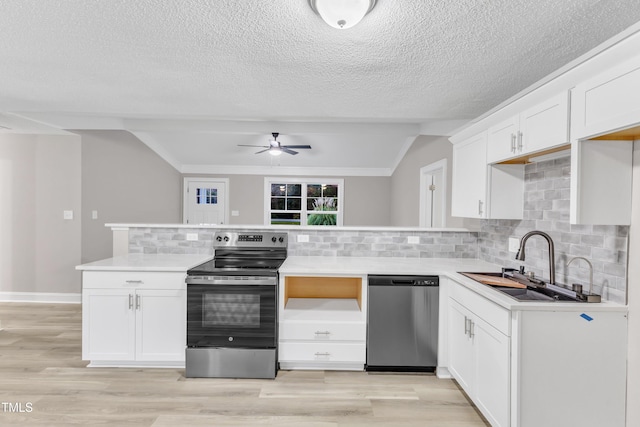 kitchen featuring vaulted ceiling, sink, white cabinets, backsplash, and stainless steel appliances