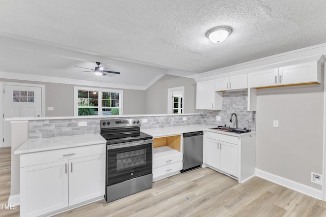 kitchen with sink, appliances with stainless steel finishes, backsplash, white cabinets, and light wood-type flooring