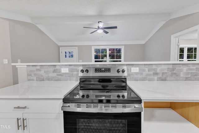 kitchen featuring electric stove, white cabinetry, vaulted ceiling, and decorative backsplash