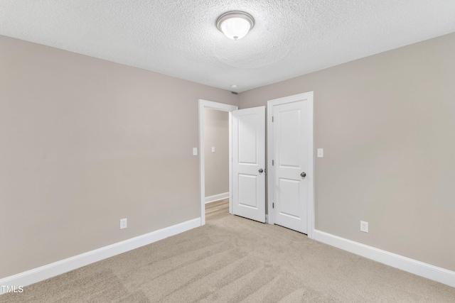 unfurnished bedroom with light carpet and a textured ceiling