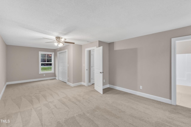 carpeted empty room with ceiling fan and a textured ceiling