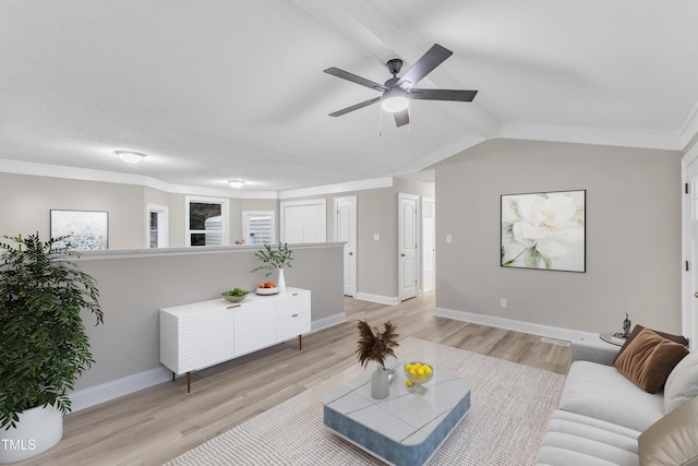 living room featuring ceiling fan, ornamental molding, vaulted ceiling, and light hardwood / wood-style flooring