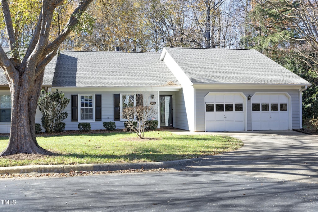 ranch-style home featuring a front yard and a garage