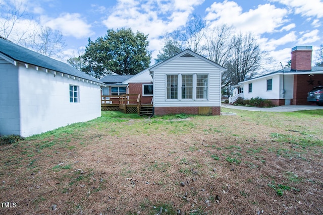 rear view of property with a yard and a deck