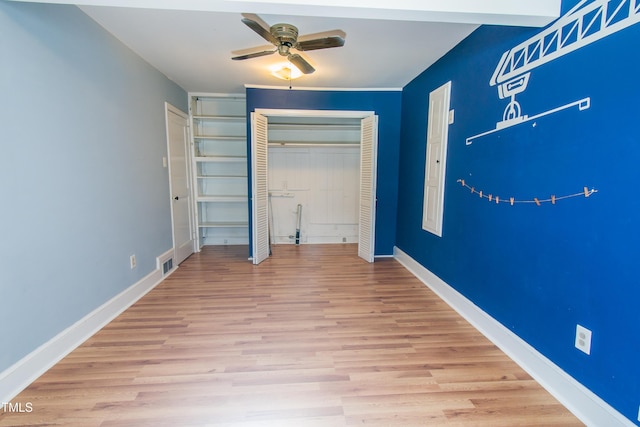 unfurnished bedroom with visible vents, wood finished floors, a closet, baseboards, and ceiling fan