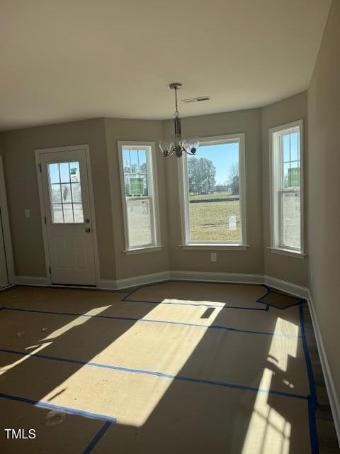 unfurnished dining area featuring basketball court and a notable chandelier