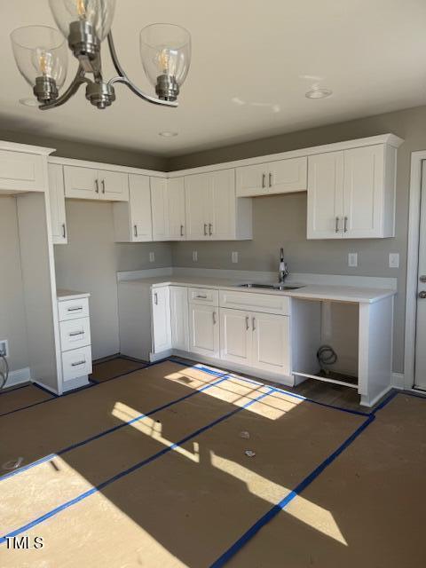 kitchen featuring a notable chandelier, white cabinetry, and sink