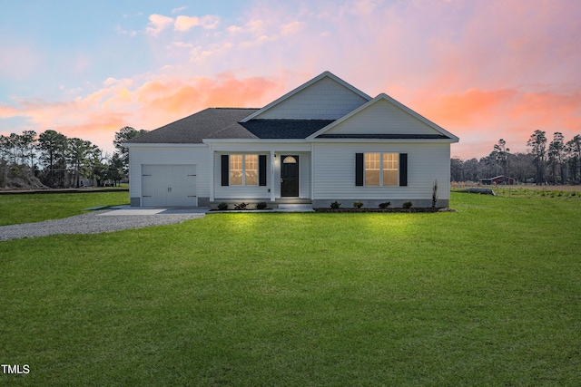 view of front of house with gravel driveway, a front lawn, a garage, and a shingled roof