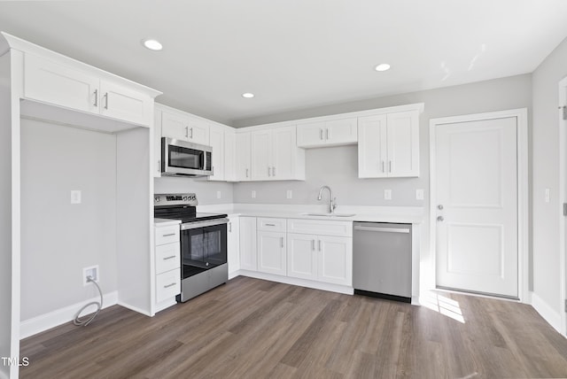 kitchen featuring stainless steel appliances, dark wood-style floors, light countertops, and white cabinetry