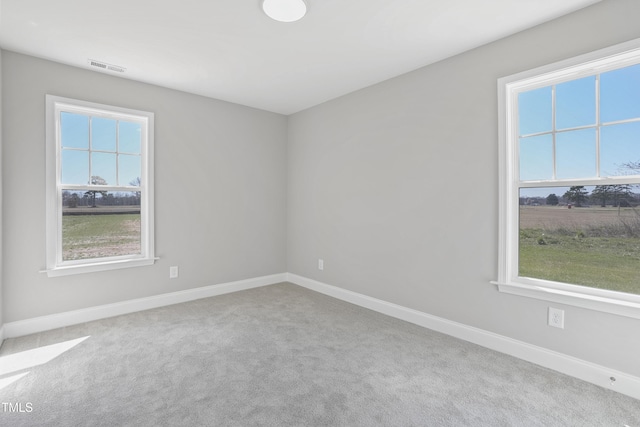 carpeted empty room with visible vents and baseboards