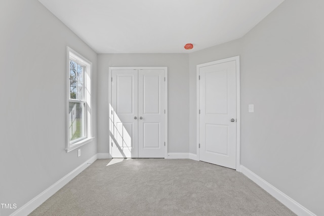 unfurnished bedroom featuring carpet flooring, baseboards, and a closet