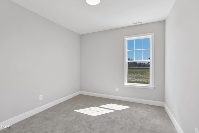 carpeted spare room with visible vents and baseboards