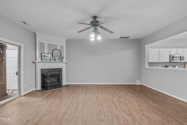 unfurnished living room featuring ceiling fan and light hardwood / wood-style flooring