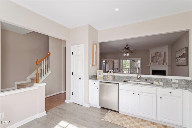 kitchen featuring white cabinetry, a sink, light stone countertops, light wood-type flooring, and dishwasher