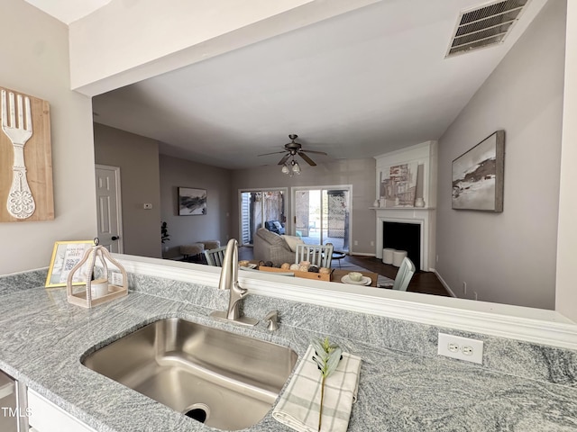 kitchen featuring a ceiling fan, light countertops, visible vents, and a sink