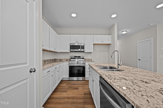 kitchen with white cabinetry, sink, dark hardwood / wood-style flooring, stainless steel appliances, and light stone countertops