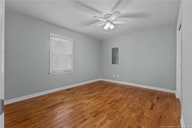 spare room with hardwood / wood-style flooring, ceiling fan, and electric panel