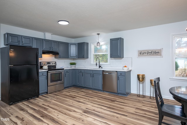 kitchen featuring decorative backsplash, sink, light hardwood / wood-style flooring, and appliances with stainless steel finishes