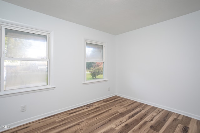 unfurnished room with hardwood / wood-style flooring