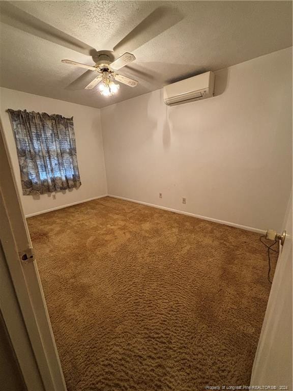 unfurnished room featuring an AC wall unit, ceiling fan, carpet floors, and a textured ceiling