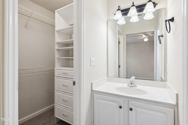 bathroom featuring ceiling fan, vanity, and a textured ceiling