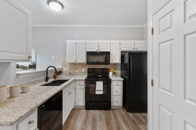 kitchen with black appliances, crown molding, white cabinetry, and sink