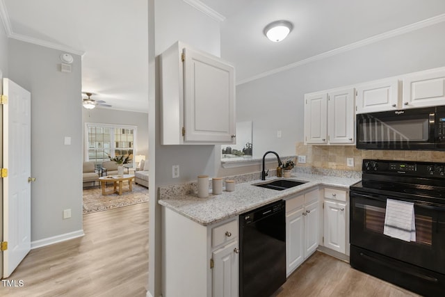 kitchen featuring black appliances, light hardwood / wood-style floors, white cabinetry, and sink