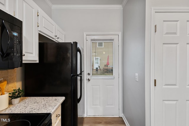 kitchen featuring white cabinets, tasteful backsplash, crown molding, and black appliances