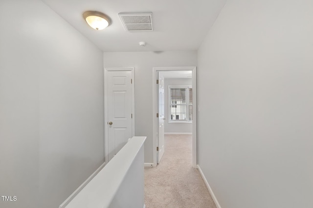 hallway featuring light colored carpet