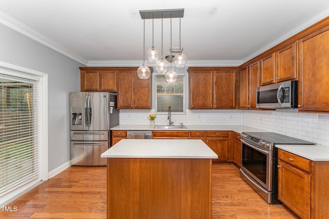 kitchen featuring appliances with stainless steel finishes, tasteful backsplash, sink, pendant lighting, and a center island