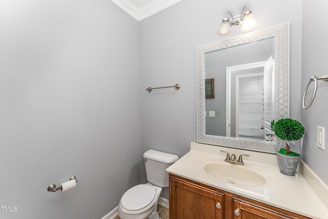 bathroom with toilet, ornamental molding, and vanity