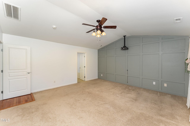 unfurnished bedroom featuring light carpet, ceiling fan, and lofted ceiling