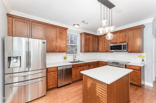 kitchen featuring stainless steel appliances, backsplash, hanging light fixtures, a kitchen island, and sink