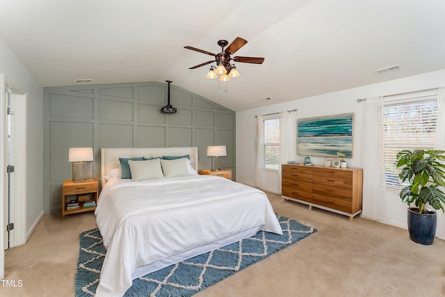 carpeted bedroom with ceiling fan, vaulted ceiling, and multiple windows