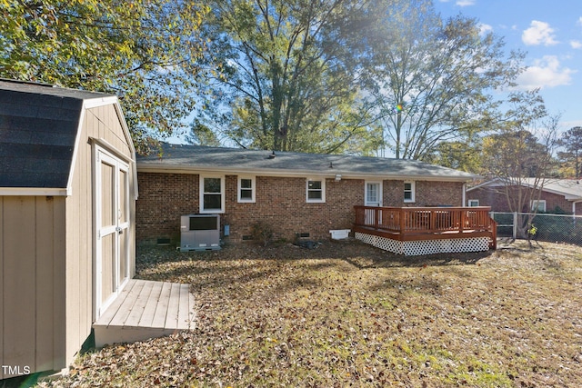 back of property with a shed and a deck